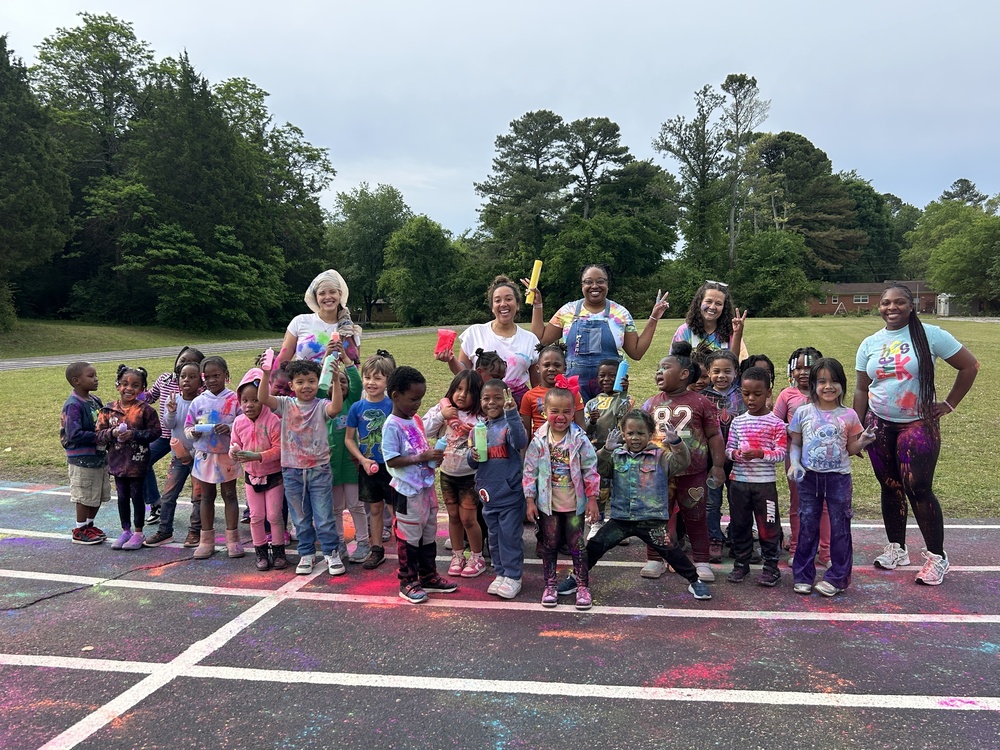 Pre-K students and teachers posing together during a colorful school color run celebration
