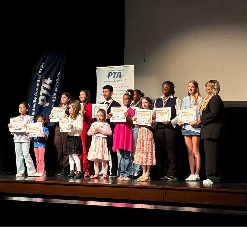 boys and girls standing on stage with their awards for the Reflections Awards
