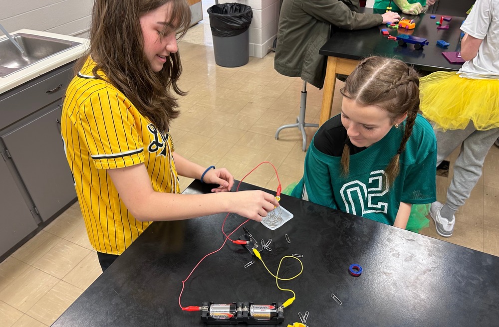 two  8th grade students experimenting with an electromagnet