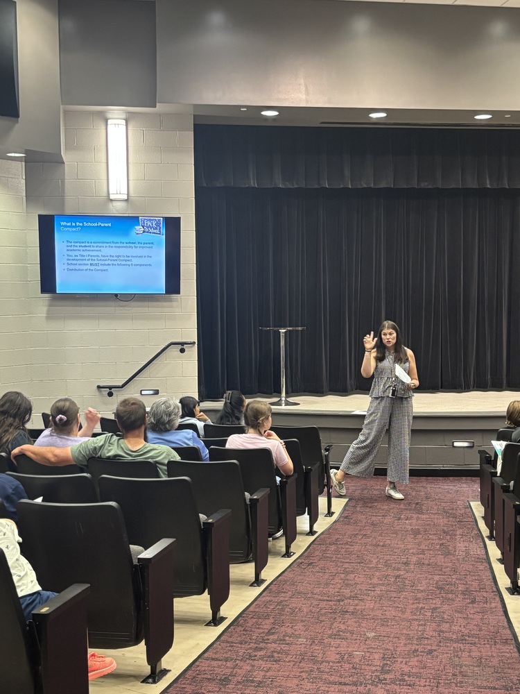 Mrs. Osborne leading the Annual Title 1 Meeting in the auditorium while families learn about their rights when sending their student to a Title 1 school.