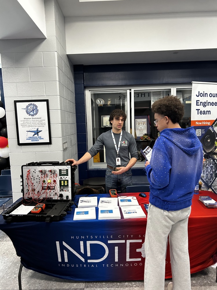 Students talk to industry and college representatives in the theater lobby at NCTHS.