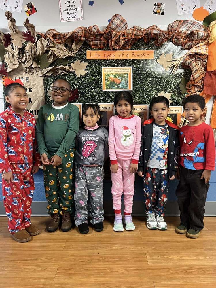 Students smile for a photo while wearing festive Christmas pajamas.