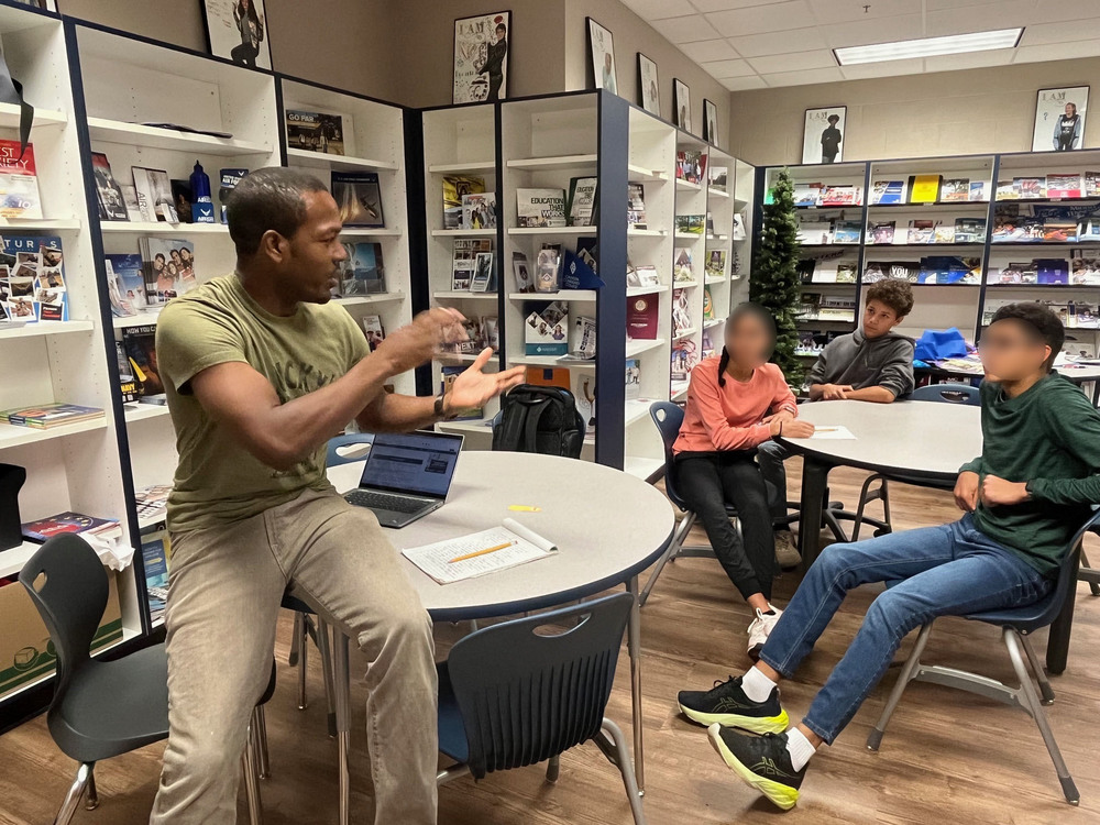 Teacher gives instruction to three students.