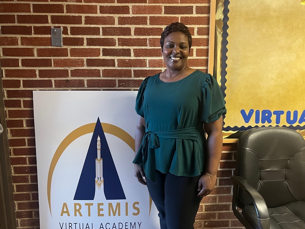 Marisha Martin stands in front of Artemis Virtual Academy sign.