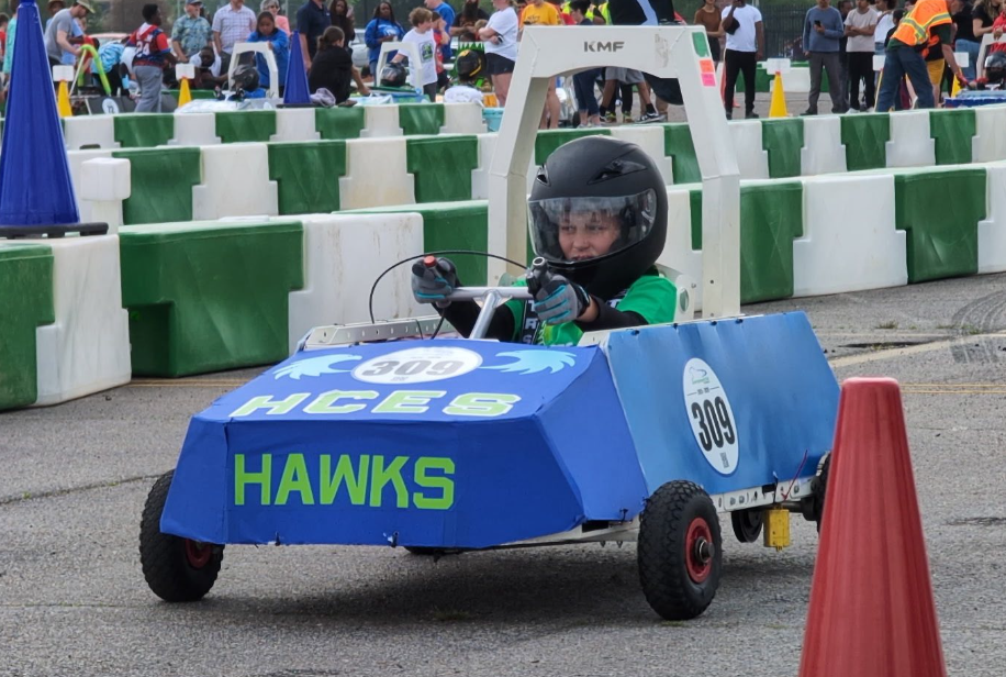 Hampton Cove student driving the blue electric car in the Greenpower Goblin Race.