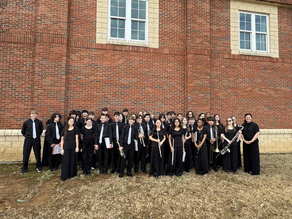 The sympphonic band standing in front of the building