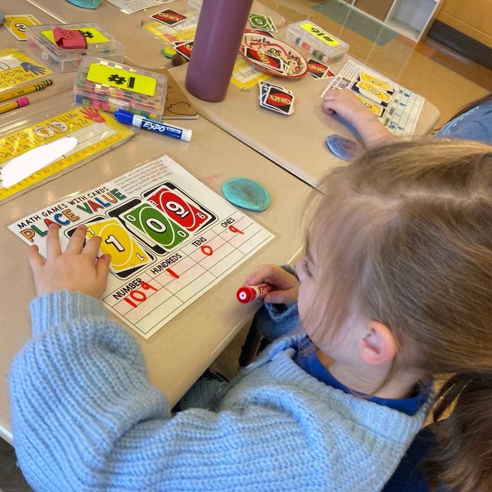 Female student works on place value mat identifying place values for digits in 109.