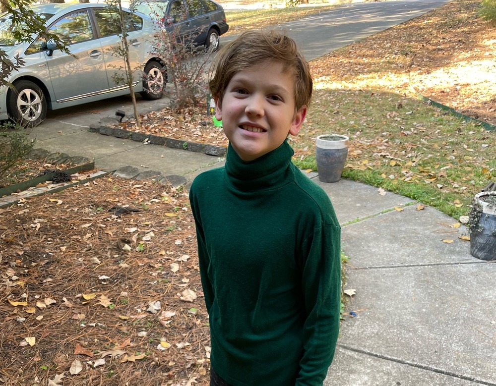 A fifth grade male student wears green to represent the first day of Red Ribbon Week.