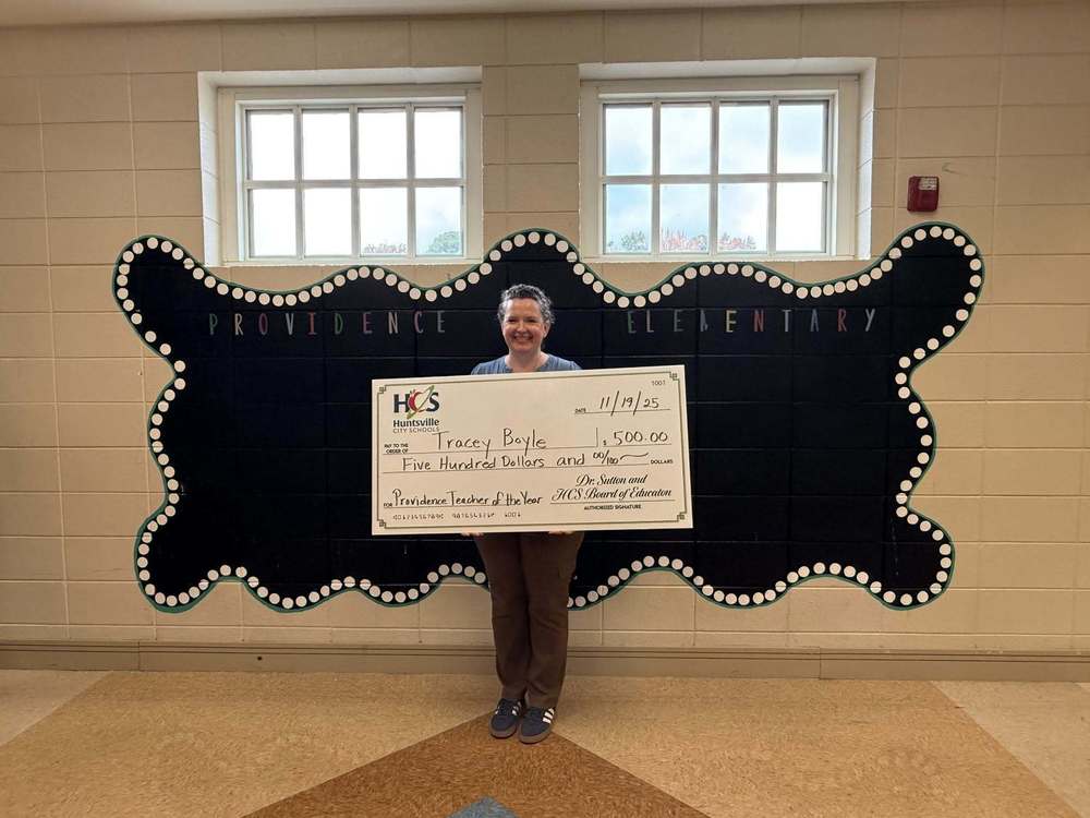 Tracey Boyle at PES, holding her check from HCS