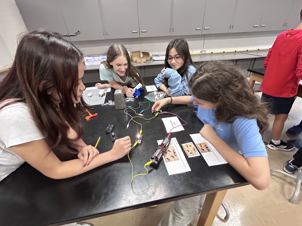 Four 8th grade students experimenting with building circuits in the lab