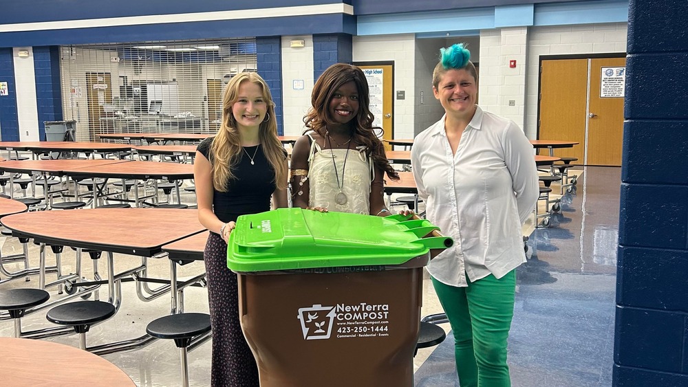 NCTHS students pose with NewTerra Compost staffer and a composting bin in the cafeteria