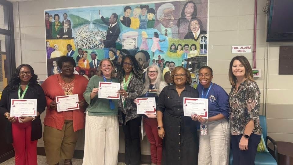 Educators pictured with certificate in hand 