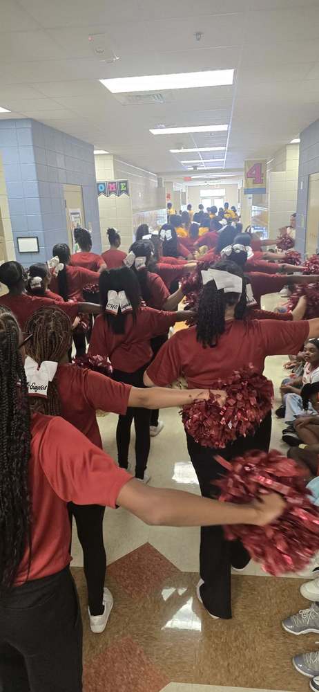 the Mighty Marching Eagles in Maroon tops and black bottoms with arms out