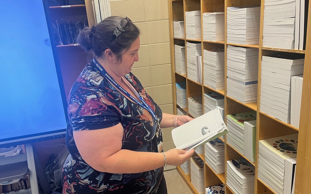 Media Specialist Stephanie Clemonslooks through a book.