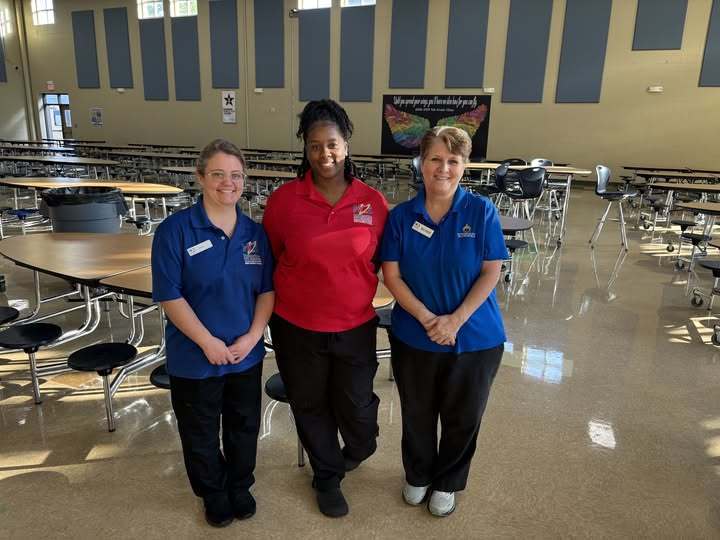 Ms. Ashley on left, Ms. Mercedes in middle, and Ms. Belinda on right are standing in the cafeteria.