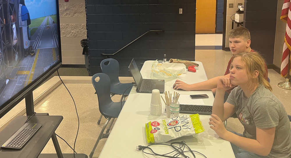 Female and male student work together to build a digital rocket.