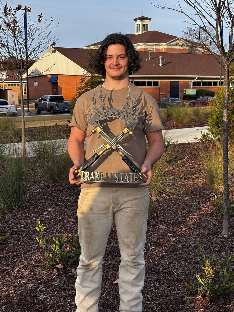 Logan Wilson poses with the Drake State Welding trophy