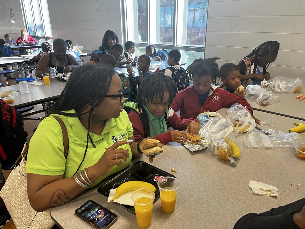 Grandparent enjoying breakfast with her grandson in Highlands Elementary School cafeteria