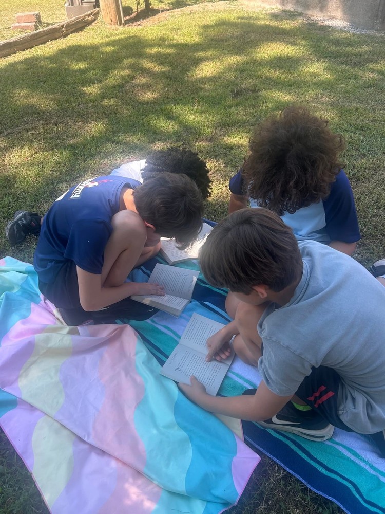 students sitting on blankets reading outside