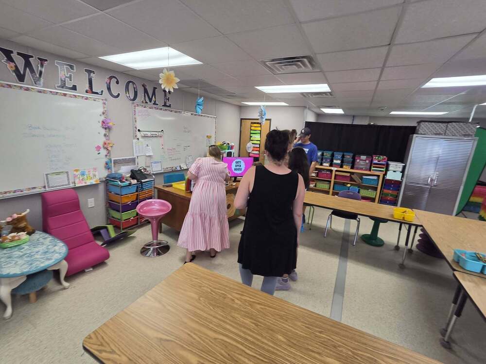 teacher and parents standing in classroom