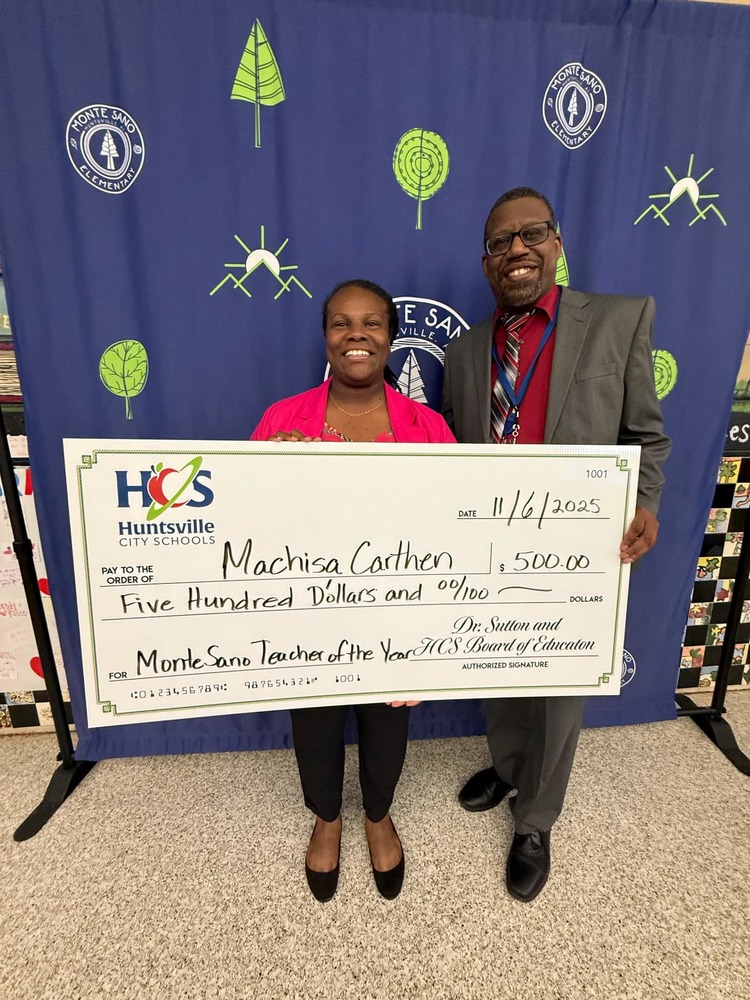 teacher and principal standing holding large check for $500