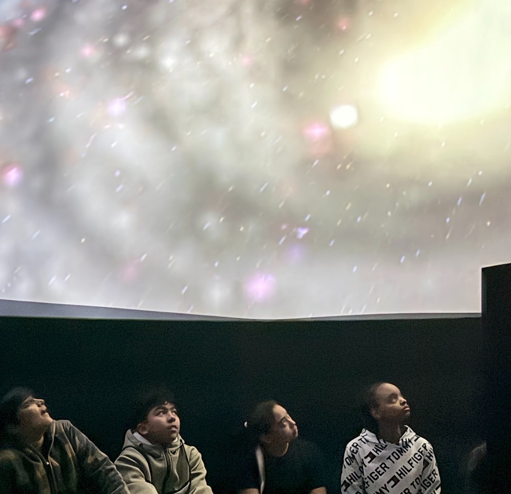 Students are pictured in the portable planetarium getting a close-up view of our night sky and distant galaxies.