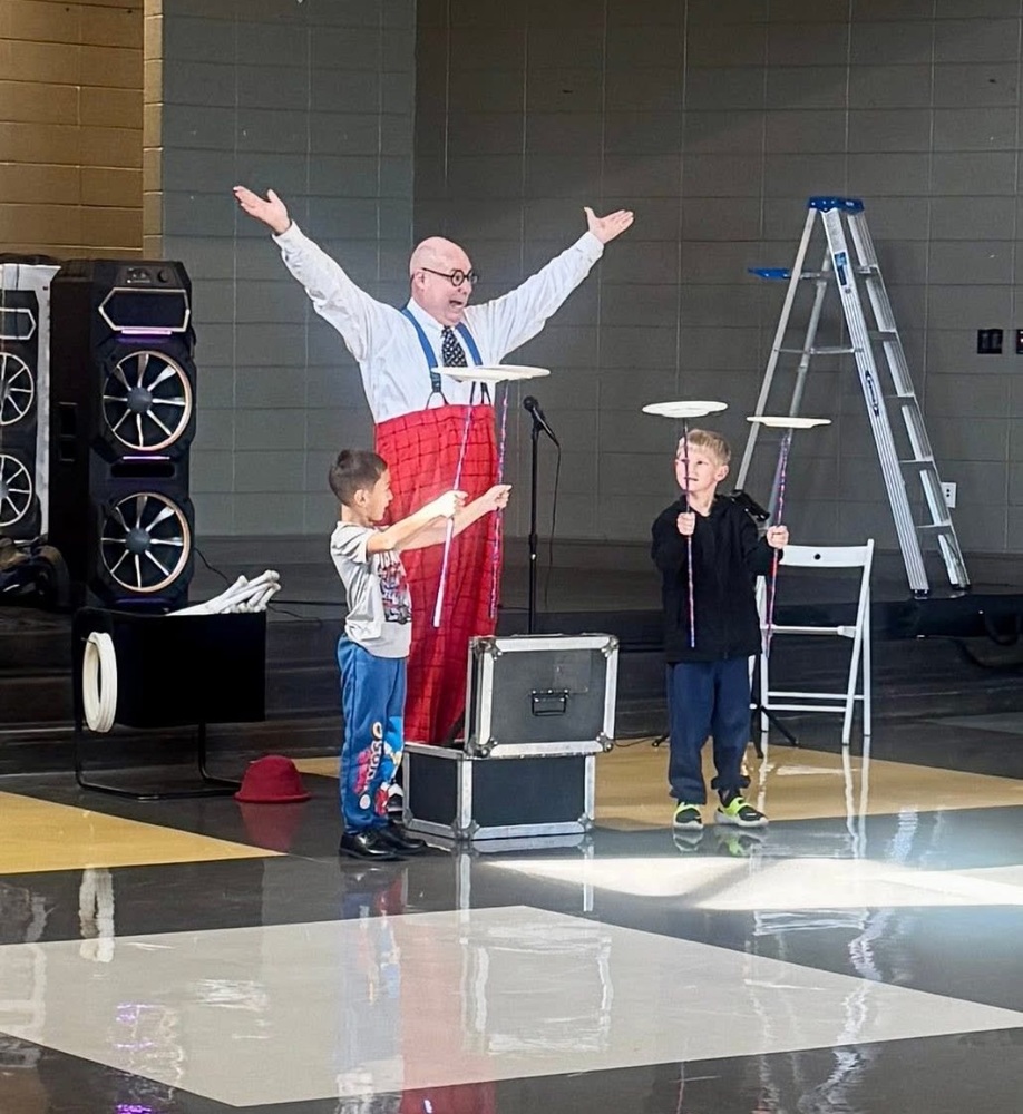 Two students balancing plates in the cafeteria for the circus
