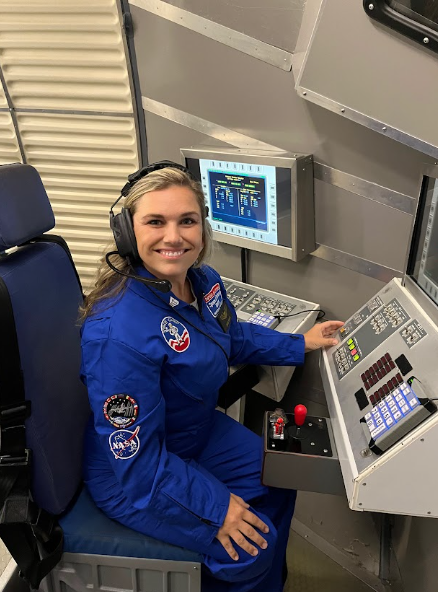 Teacher smiling while working controls at an electronic simulator