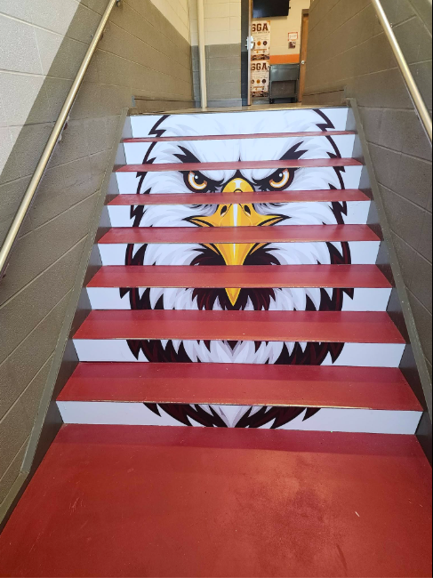 A stairwell in which each riser has a part of an image of an eagle printed on it. Looking from the landing it forms the complete image on a eagle's head.