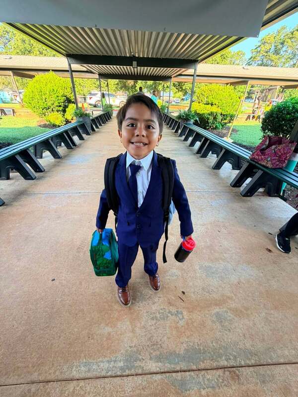A student dressed for success as he enters the school.