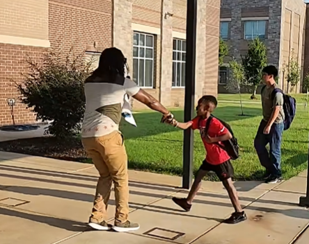 Mr. Palmer greets a students with a fist-bump