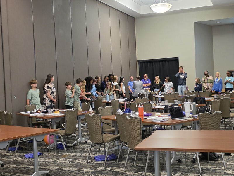 Columbia S2S students standind around tables at the summit