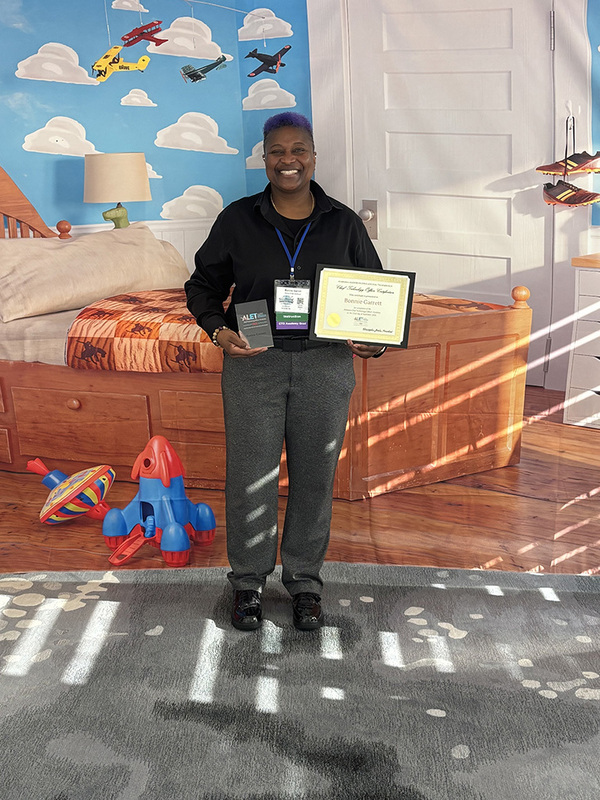 Bonnie Garrett holding her certificate at ALET