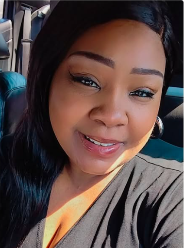 Ms. Dorothy Taylor snapped a selfie in her car. She's wearing a black shirt.