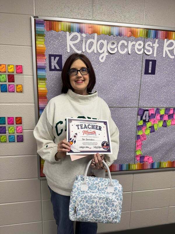 Mrs. Barksdale posing with her Teacher of the Month certificate