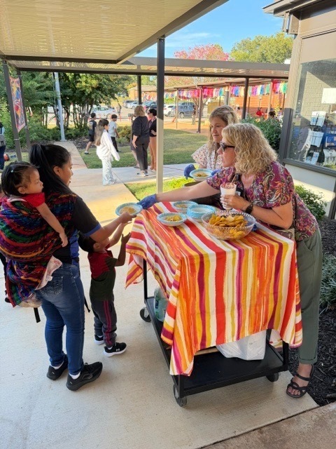 Mrs. Brooks and Mrs. Preston serving chips and salsa donated by El Coyote.