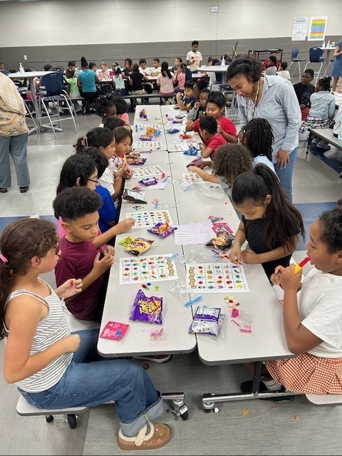 First and fourth graders concentrating on their loteria cards.