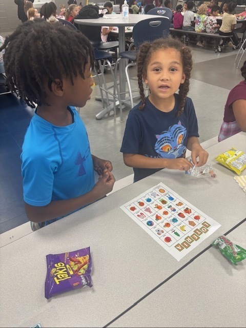 Kindergartener and his second grade partner playing loteria.