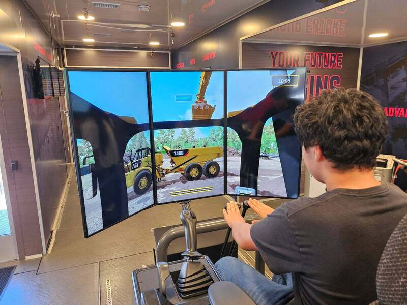 a student sits in the "driver's seat" of a contruction simulator.