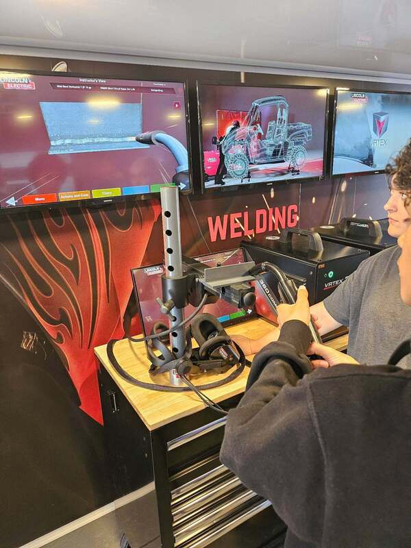 A students runs a simulation of welding equipment.