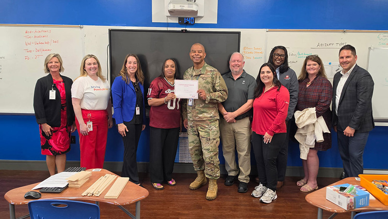 Principal Leverett & Jemison staff pose with district staff and Toyota Reps as they accept their grant certificate