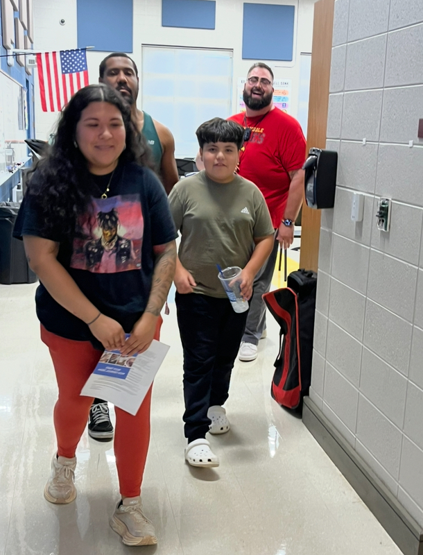 Mr. Davis greets a student and his parents in the band room