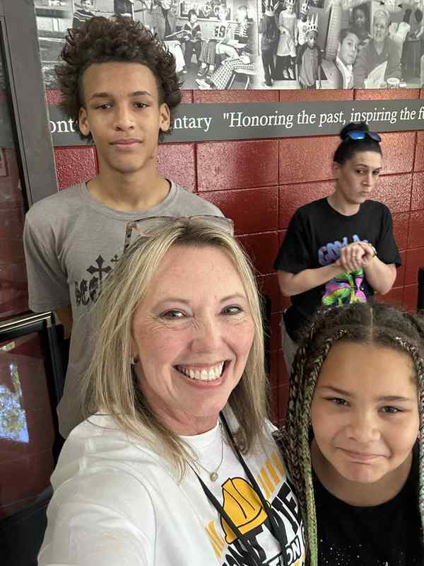 Photo of Principal Sutton with a former student and his sister in 3rd grade.