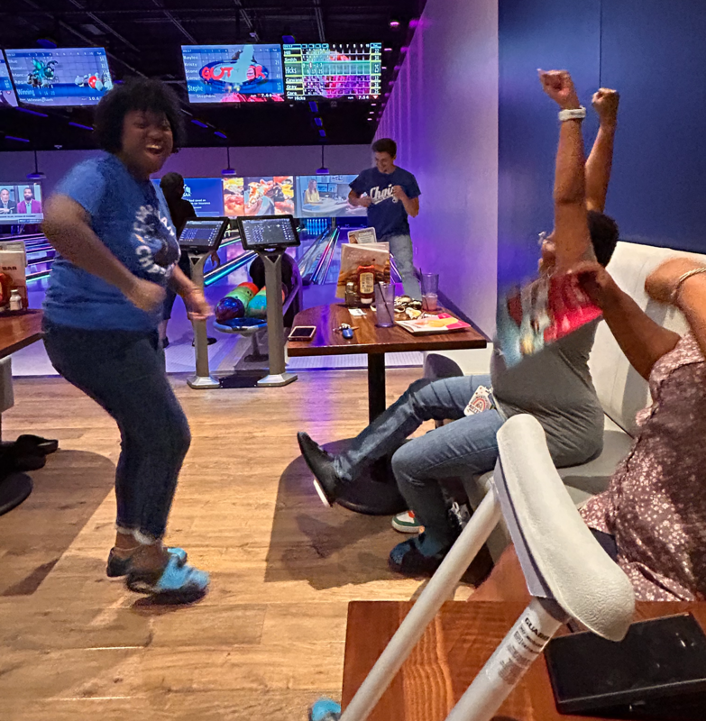 Mrs. Smith and Ms. Cowans celebrate Mr. Hicks's strike at the Main Event.