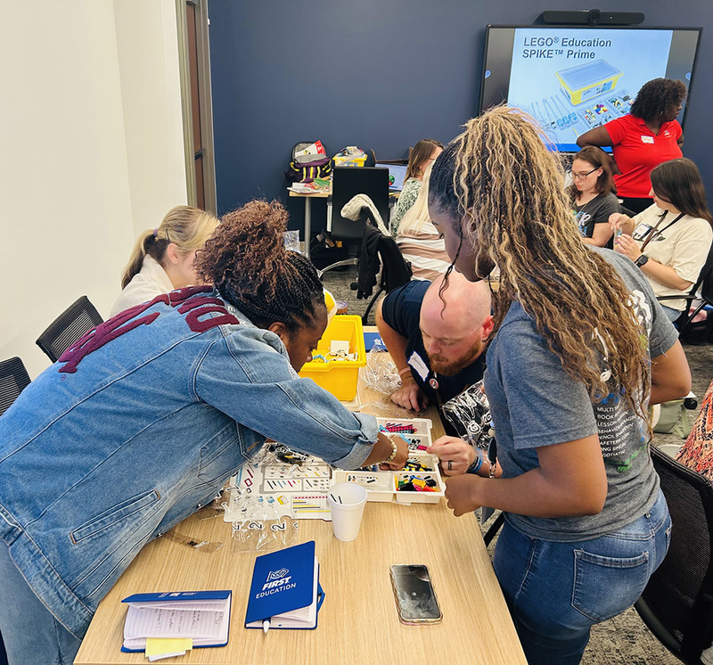 Elementary robotics teachers  working together to build a LEGO robot