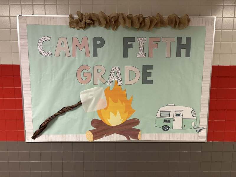 Bulletin Board advertising Camp Fifth Grade with a fire and a marshmallow roasting.