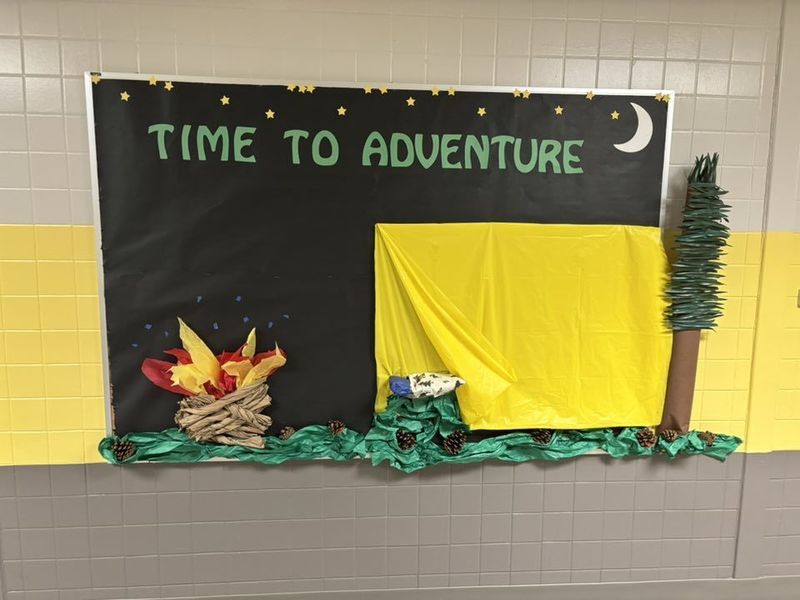 A bulletin board with a tent, fire, and tree and the words "Time to Adventure"