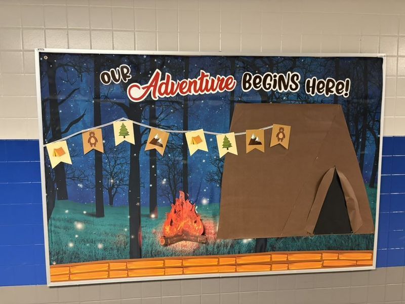 A tent and the words "Our Adventure Begins Here" on a bulletin board