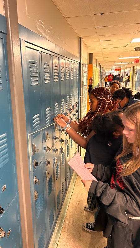 Students are working to construct a number line in the hallway during math class.