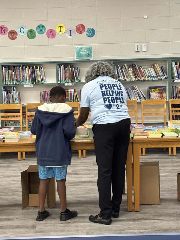 A Redstone Federal Credit Union volunteer helping a student